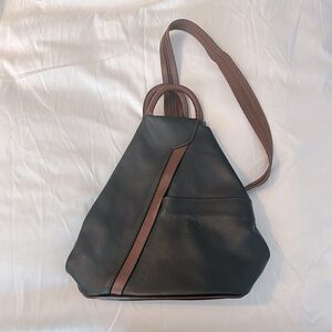 This black and tan sling backpack is made from genuine leather in Italy.
